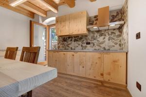 a kitchen with wooden cabinets and a table at Casa al Mulino 1 in Tenno +19 photos