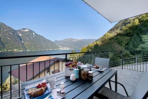 a table with a bowl of fruit on top of a balcony at Appartamento 1 Il Tornante in Nesso
