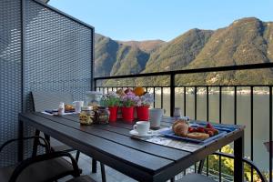 a table with a tray of food on a balcony at Appartamento 1 Il Tornante in Nesso