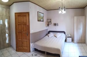 a small bedroom with a bed and a door at CSABA-EMILKA-SPA Apartmanok in Hajdúszoboszló