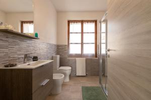 a bathroom with a toilet and a sink and a window at Casa Belvedere in Codrongianos