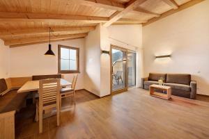 a living room with a table and a couch at Unterötzbauerhof - Fewo Rosenblick in Tirolo