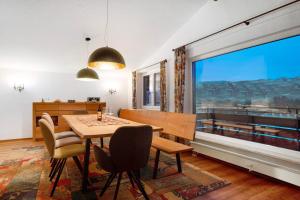 a dining room with a table and chairs and a large window at Nini´s Berge in Sonthofen