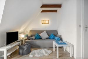 a living room with a couch and a tv at Fewo Silbermöwe in Pellworm