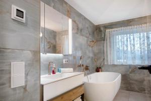a bathroom with a sink and a tub and a mirror at Nini´s Berge in Sonthofen +22 photos
