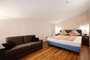 a bedroom with a bed and a couch at Nini´s Berge in Sonthofen