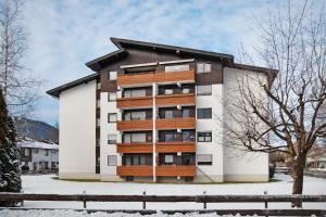 an apartment building with wooden balconies in the snow at Nini´s Berge in Sonthofen