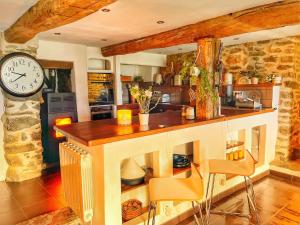 a kitchen with a counter and a clock on a wall at Le Grand Mas de Can Noy in Montferrer