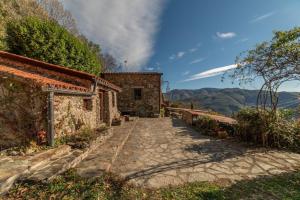 a stone path leading to a building with mountains in the background at Le Grand Mas de Can Noy in Montferrer +16 photos