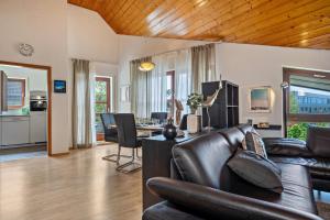 a living room with a leather couch and a table at Appartement Seefreunde in Langenargen