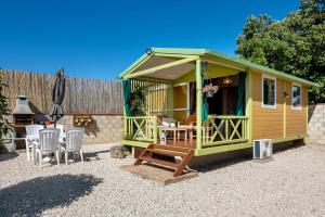 a green cabin with chairs and a table and chairs at La Breña in Barbate