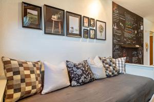 a couch with pillows on it with a wall with pictures at Appartement Seefreunde in Langenargen