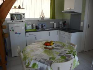 a kitchen with a table with a bowl of fruit on it at La Voile Blanche - 36 in Pornic
