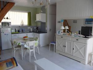 a kitchen with a table and a kitchen with a dining room at La Voile Blanche - 36 in Pornic
