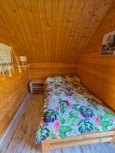 a bed in a room with a wooden ceiling at Domki przy Młynie " Koło Młyńskie " in Krościenko