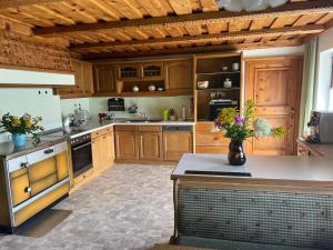 a large kitchen with wooden cabinets and a vase of flowers at Oberbründlingchalet in Taxenbach