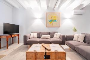 a living room with a couch and a tv at Casa La Roca in Pollença