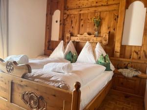 a bedroom with a bed with a wooden wall at Oberbründlingchalet in Taxenbach