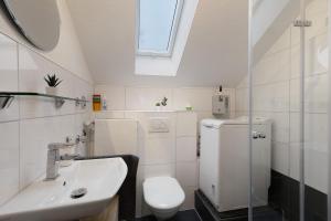 a white bathroom with a toilet and a sink at Tifra-living in Hardenberg