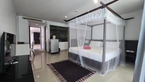 a bedroom with a bed with a canopy at joyful theKris 205 in Ban Lum Fuang