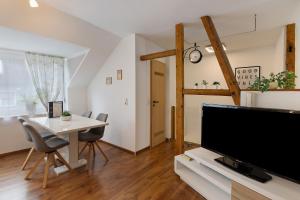 a living room with a tv and a table with chairs at Tifra-living in Hardenberg