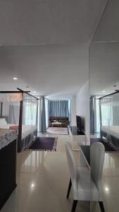 a bedroom with two beds and a table and chairs at joyful theKris 205 in Ban Lum Fuang