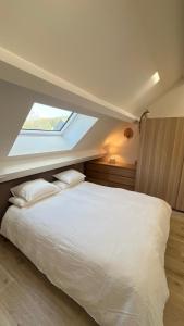a bedroom with a large white bed with a window at Deluxe home garden and pool optional pm in Kortenberg