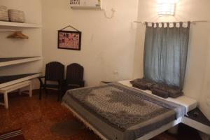 a small bedroom with a bed and a desk at Mint Inside Garden in Varkala +10 photos