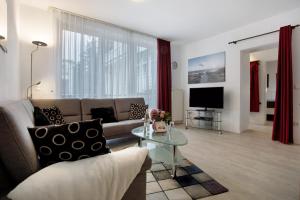 a living room with a couch and a tv at Wohnung C1 - Haus A Cappella in Binz