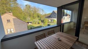 a balcony with a wooden table and a large window at Deluxe home garden and pool optional pm in Kortenberg