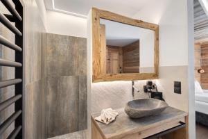 a bathroom with a stone sink and a mirror at Chalet-Suite Wald in Selva dei Molini +31 photos