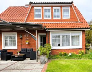 a red brick house with an orange roof at ANKERHUUS Norddeich in Norddeich
