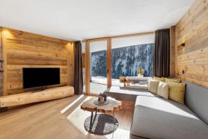 a living room with a couch and a tv at Chalet-Suite Wald in Selva dei Molini