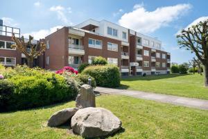 an apartment building with a rock in the yard at Wellness Ferienwohnung Strandperle in Cuxhaven