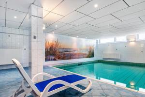 a swimming pool with a chair next to a swimming pool at Wellness Ferienwohnung Strandperle in Cuxhaven
