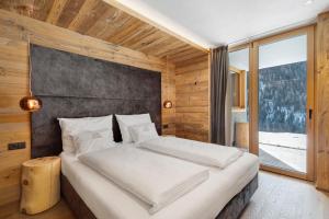 a bedroom with a bed and a large window at Chalet-Suite Wald in Selva dei Molini