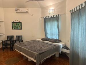 a bedroom with a bed with blue curtains at Mint Inside Garden in Varkala