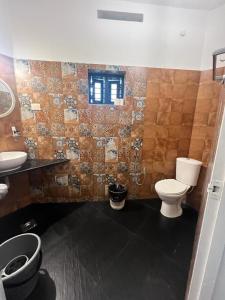 a bathroom with a toilet and a sink at Mint Inside Garden in Varkala