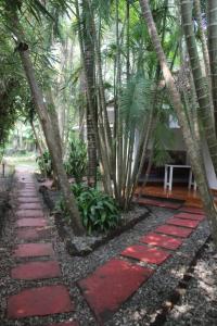 a garden with red stepping stones and palm trees at Mint Inside Garden in Varkala