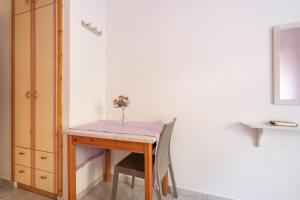 a small table with a vase of flowers on it at Nontas Home 25 in Kalamitsi +18 photos