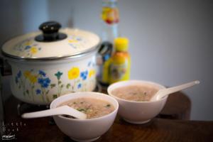 two bowls of soup on a wooden table with a pot at Retro Twin Home @Maesot in Mae Sot