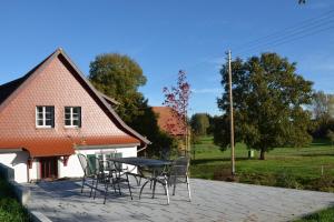 a patio with a table and chairs in front of a house at Landluft Ferien - Wohnung Abendrot in Heiligenberg