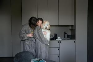 two women hugging a dog in a kitchen at Mana Sleep & Spa in Druskininkai +103 photos