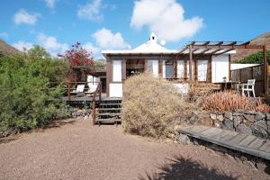 a small house with a stone wall at Ecolodge Finca Chafariz in Tabayesco