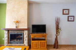 a living room with a tv and a fireplace at La Casa de Dafne Acebo in Santo Tomé del Puerto