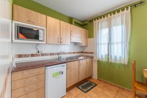 a small kitchen with a sink and a microwave at La Casa de Dafne Acebo in Santo Tomé del Puerto +20 photos