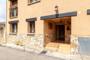 a building with a stone wall and a door at La Casa de Dafne Acebo in Santo Tomé del Puerto