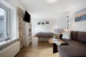 a living room with a couch and a bed at De lütt Stuf - Urlaub mit Hund in Born