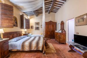 a bedroom with a bed and a television in it at Antiche Dimore Del Vescovado in Siena