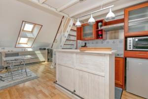 a kitchen with wooden cabinets and a counter top at Appartement face mer et Piscine in Le Croisic